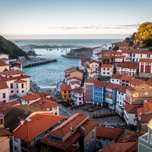 A landscape of Cudillero surrounded by hills and sea under the sunlight in Spain